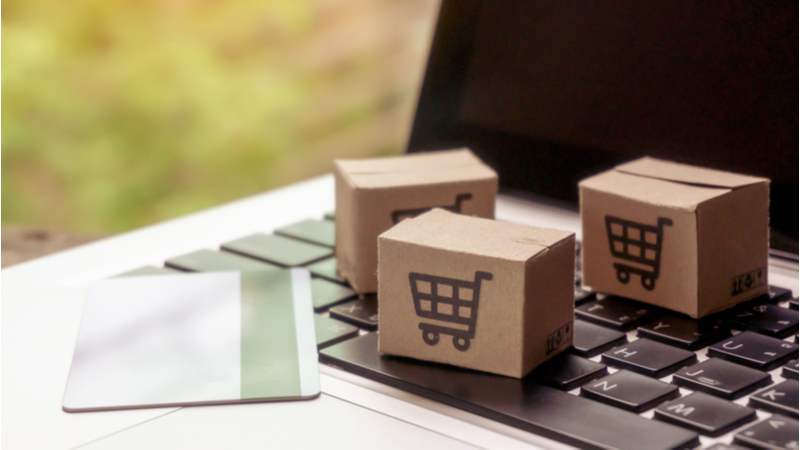 scatole con disegnato carrello della spesa appoggiate su tastiera PC